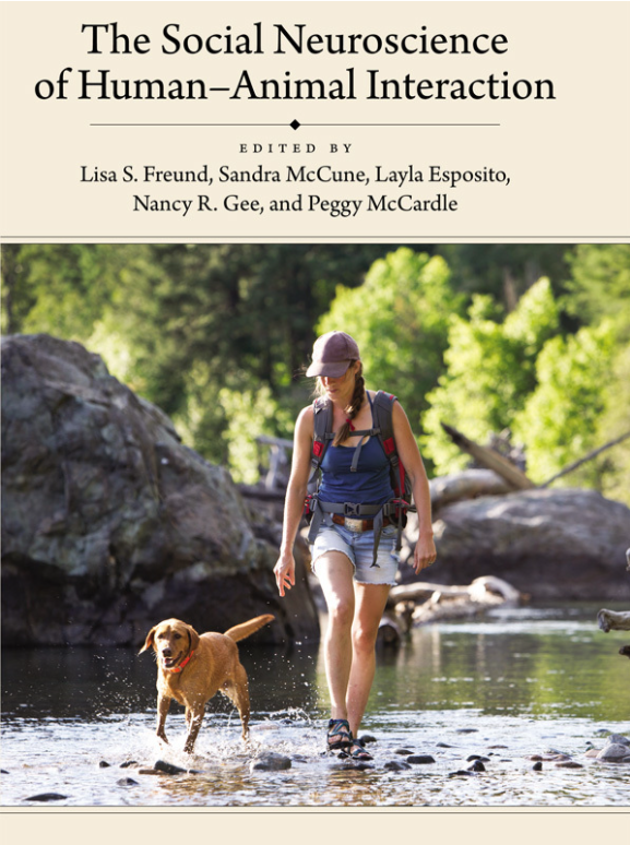 Book cover for The Social Neuroscience of Human-Animal Interaction featuring a mixed-breed dog and their owner going for a hike down a stream.
