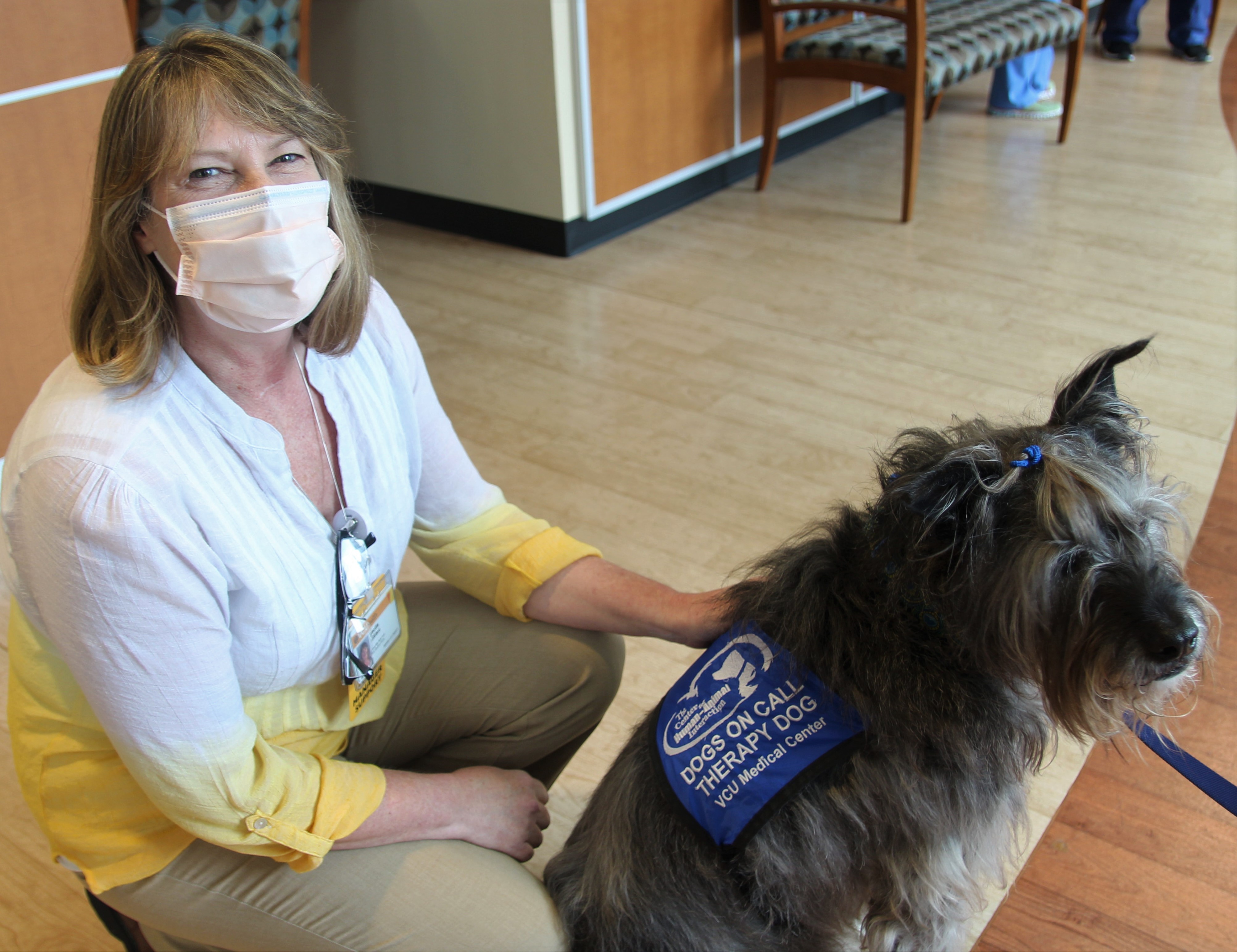 terrier mix therapy dog Zeke with VCU Health worker in hallway