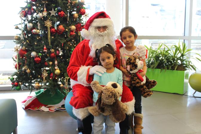 two sisters with toys and santa