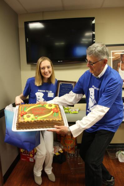 Dr. Randy Barker, Center volunteer, holds a cake which reads 